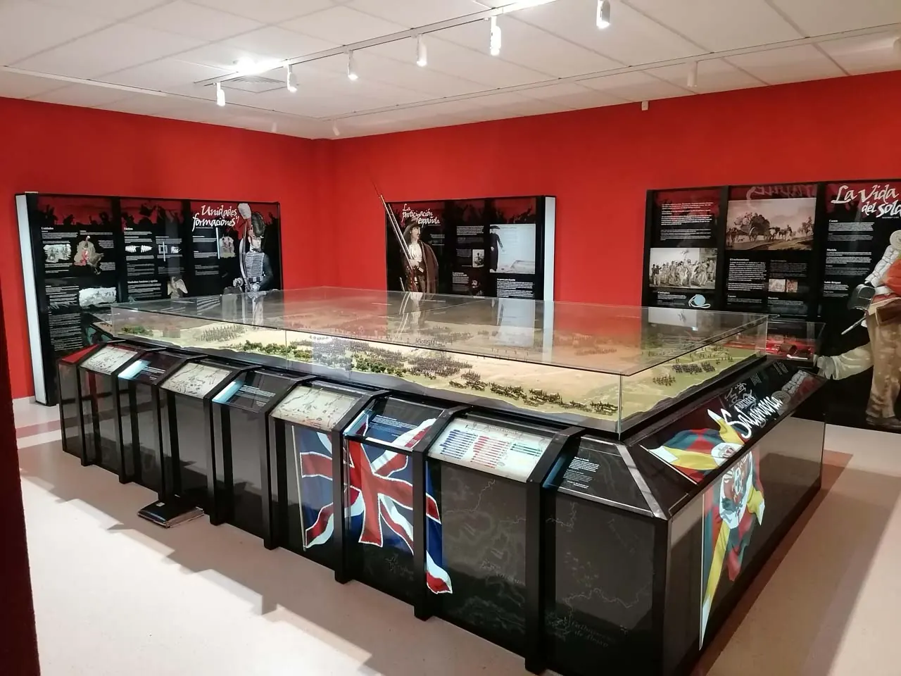 Sala del Museo de la Batalla de Arapiles: vitrina central con maqueta del despliegue militar y paneles expositivos sobre las unidades, la participación española y la vida del soldado.